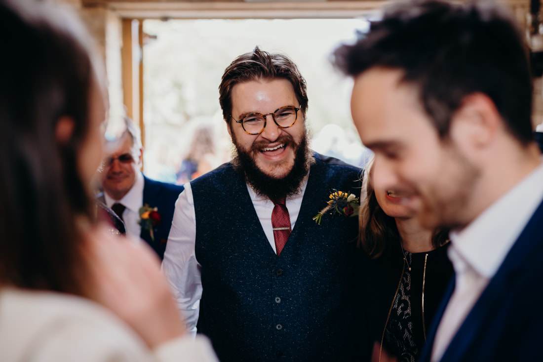 Bearded man laughing at wedding
